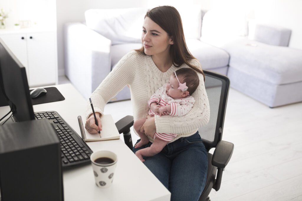 woman-writing-and-holding-baby